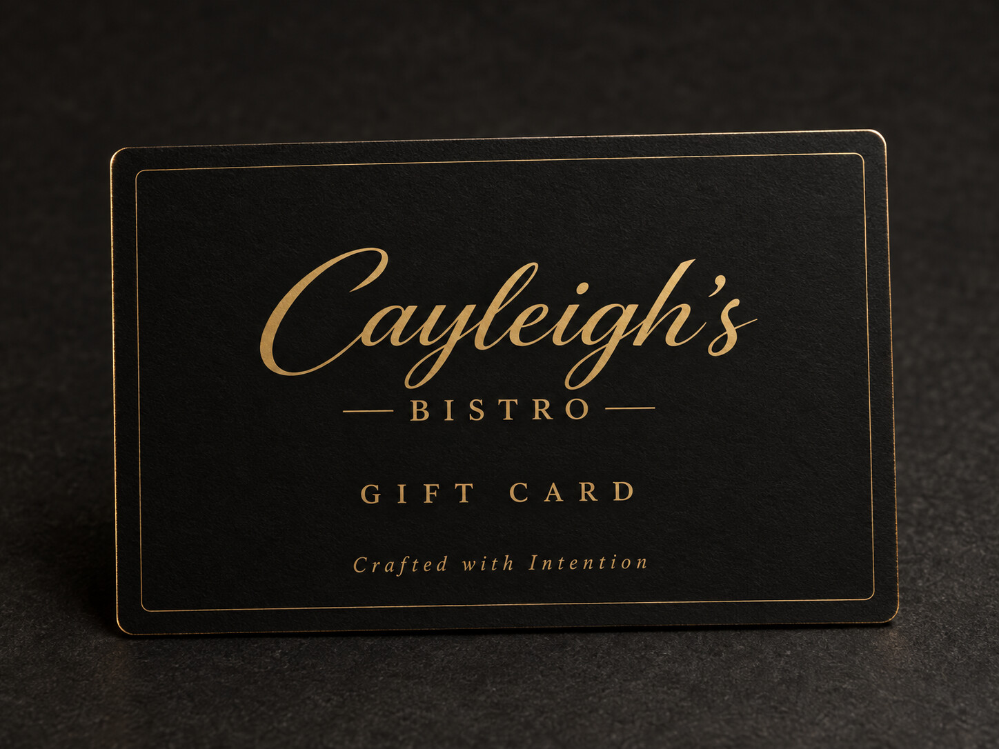 Classic matte black Cayleigh’s Bistro gift card with gold script lettering and a fine gold border